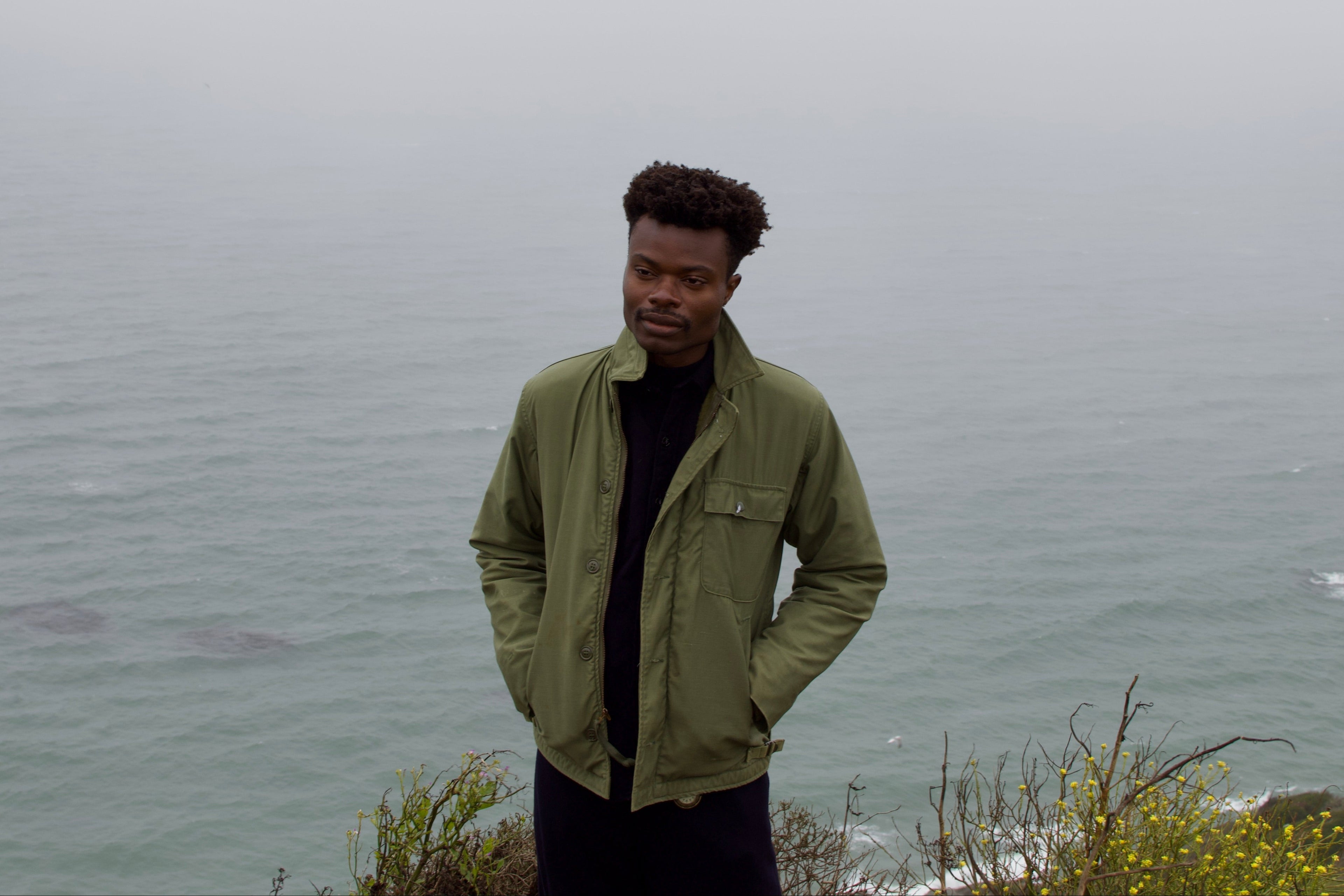 Person standing on a cliff overlooking a foggy ocean